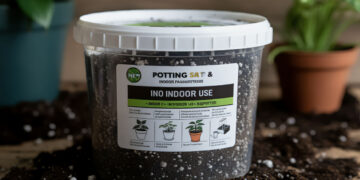 Container of indoor potting soil on a wooden surface with spilled soil around
